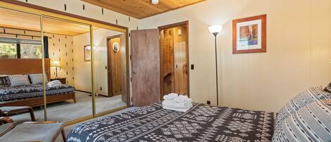 Une chambre avec un grand lit, un plafond en bois et un miroir.