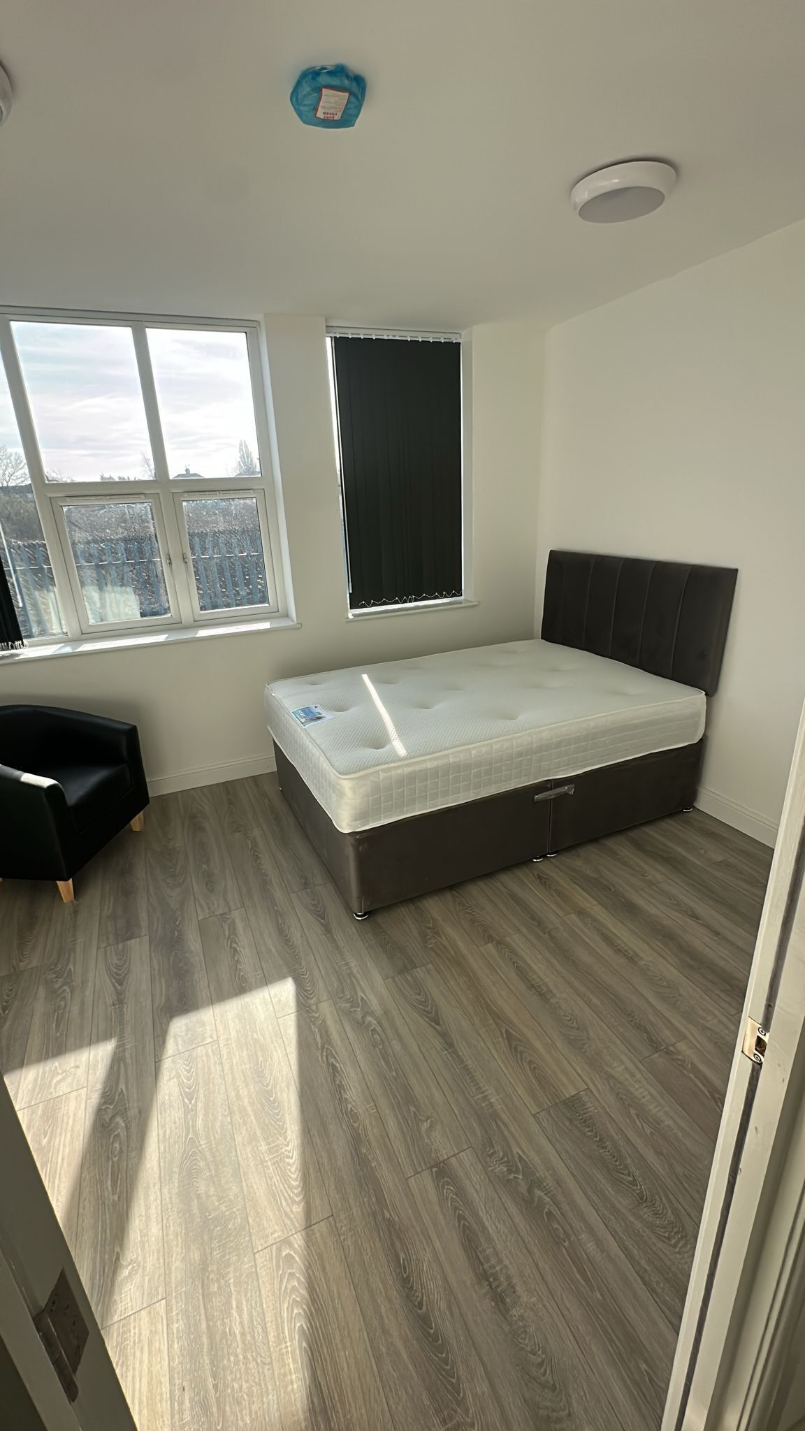 A bedroom with a bed, a window, and a view of the city.