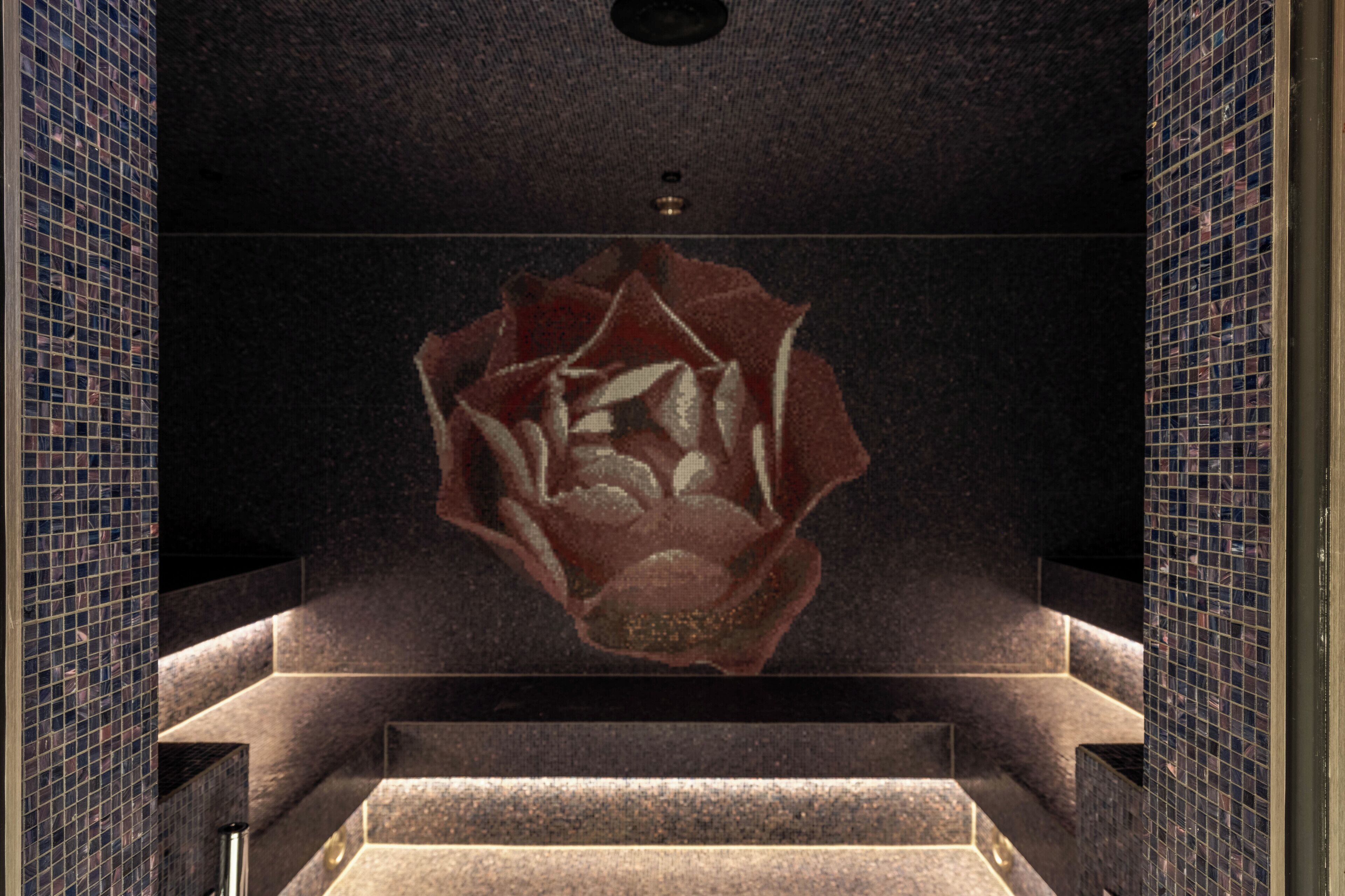 Une salle de bain moderne avec un grand motif de rose géométrique sur le mur, une baignoire et un espace douche.