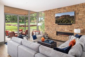 TV connectée, cheminée, livres, chaîne hi-fi