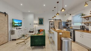 A modern kitchen with a central island, built-in appliances, and pendant lighting. - Midtown 2BR | Walk to Piedmont Park + Beltline (Atlanta)