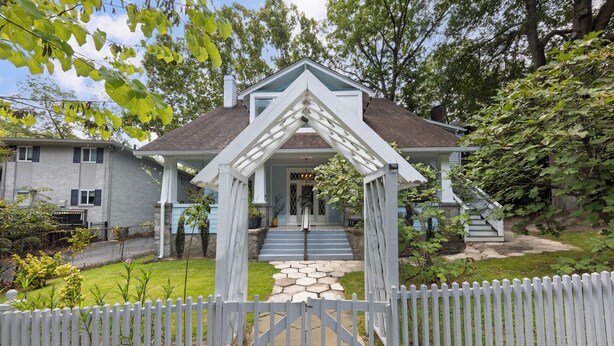 A house with a white picket fence, a stone pathway leading to the front door, and a covered porch. - Midtown 2BR | Walk to Piedmont Park + Beltline (Atlanta)