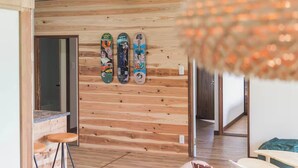A room with wooden panel walls, a staircase, and a hanging light fixture.