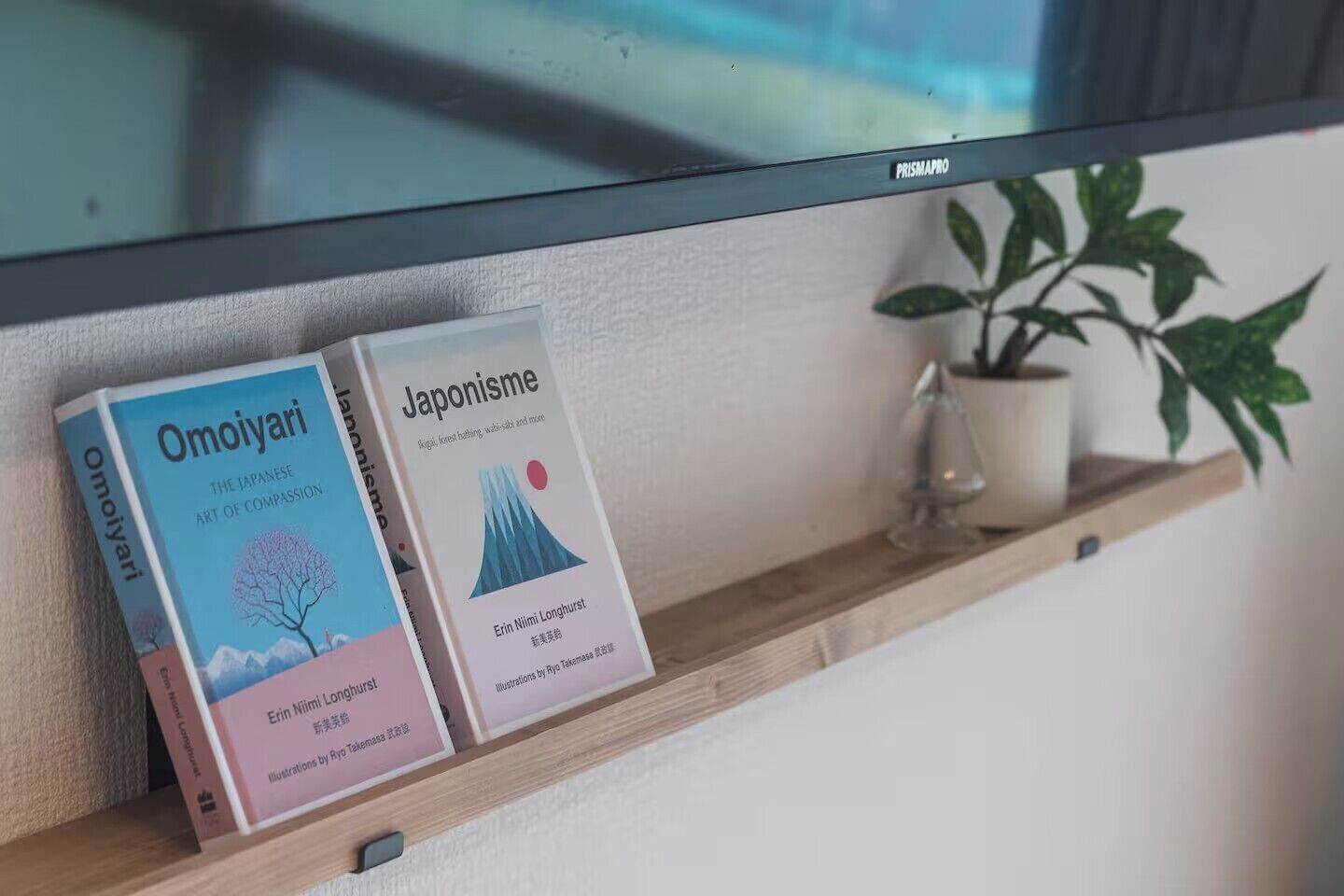 Dos libros titulados 'Omoiyari' y 'Japanisme' sobre una estantería.