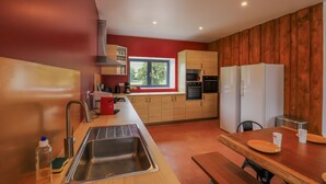 A modern kitchen with wooden cabinets, a stainless steel sink, and a window providing natural light.
