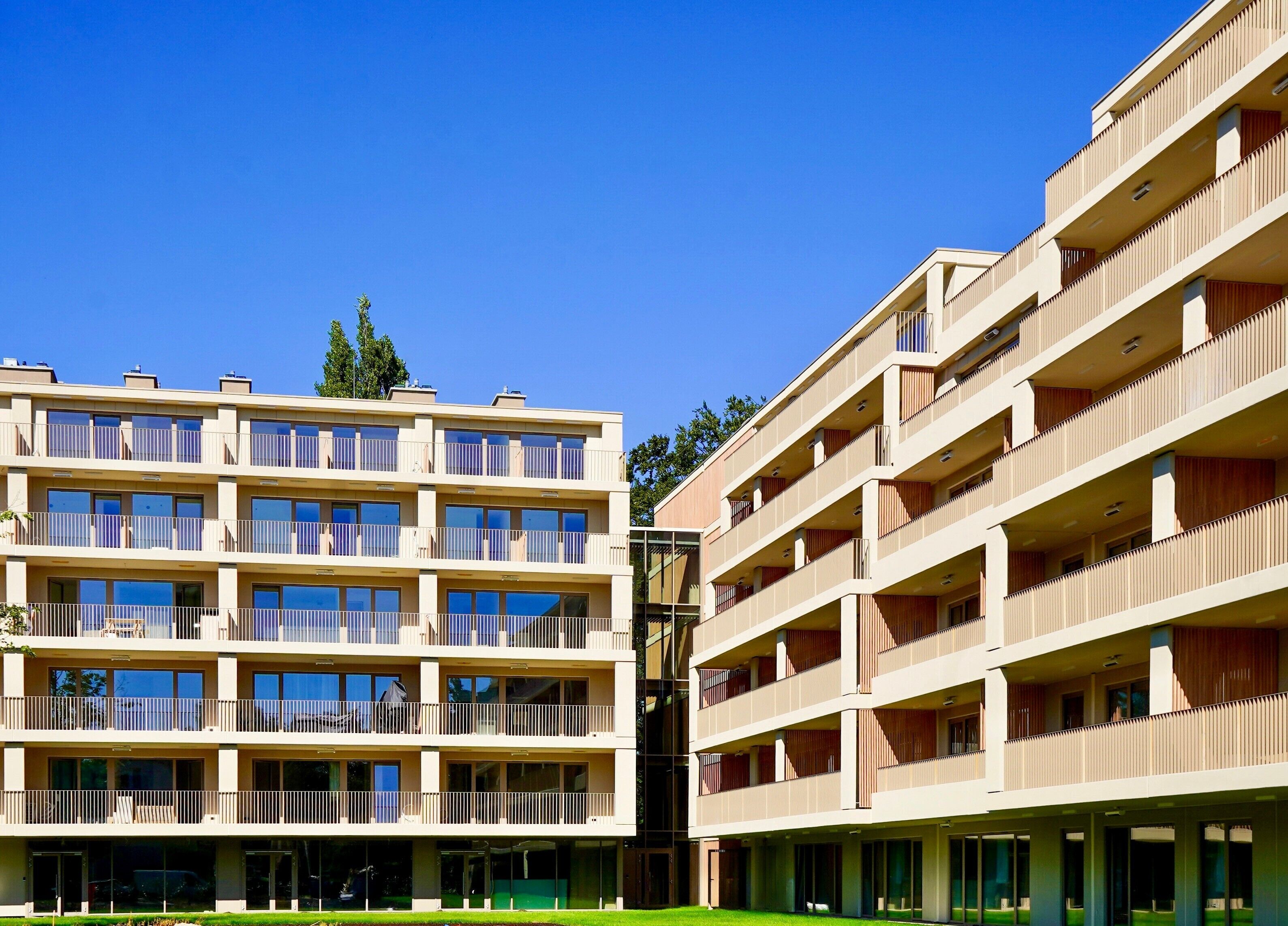 A multi-story hotel with balconies, large windows, and a central courtyard.