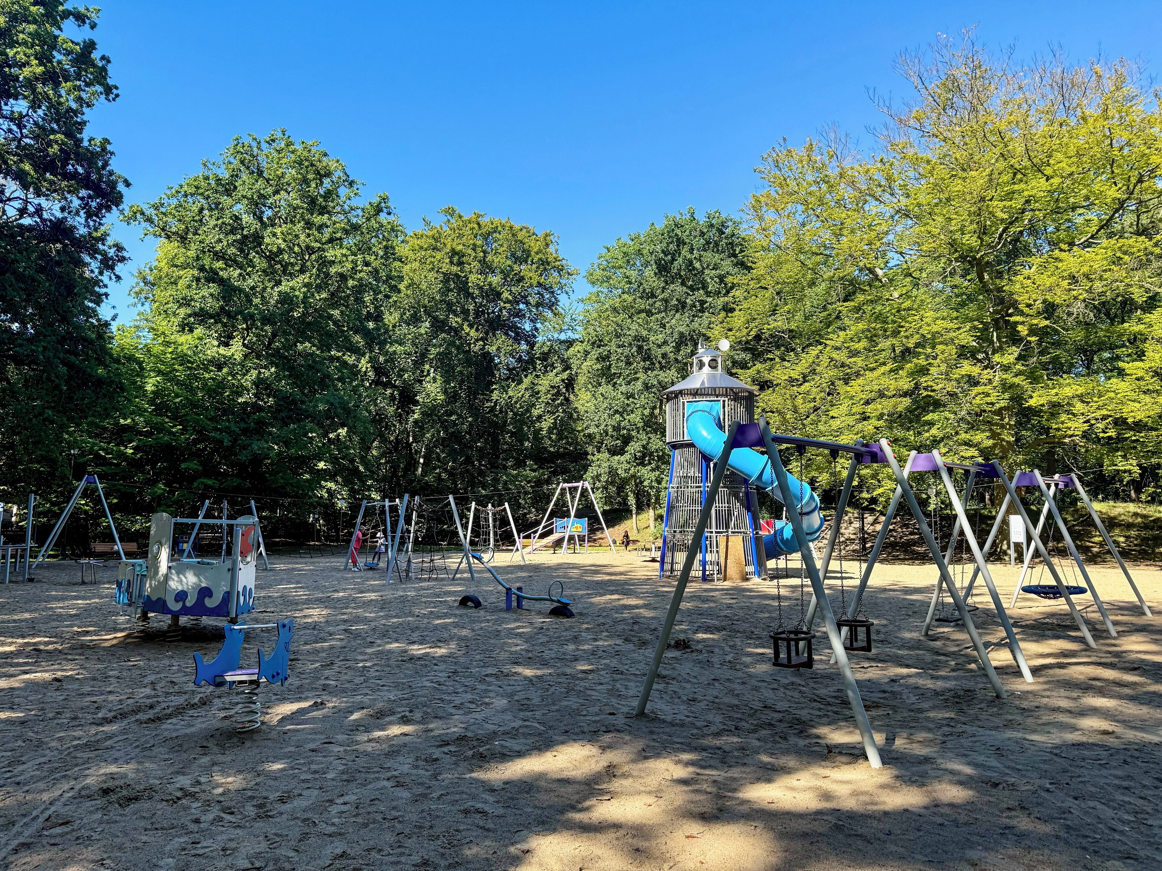 A playground with swings, a slide, and a climbing structure.