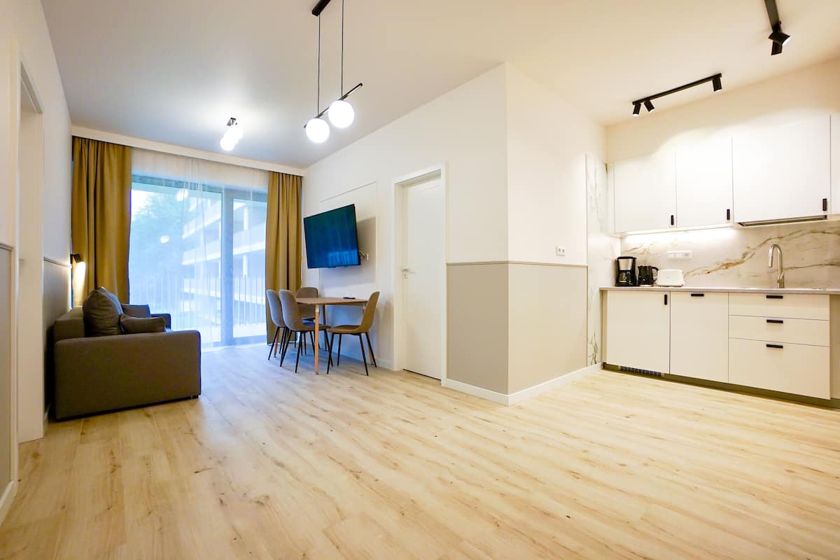 Un appartement moderne comprenant un espace de vie, un coin repas et une cuisine.
