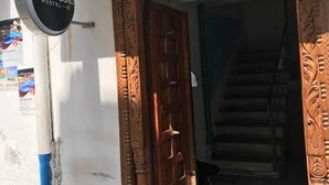 Entrada a un hostal con una puerta de madera y un letrero que dice 'LOST & FOUND HOSTEL 57'.