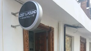 Un hostal llamado "LOST & FOUND HOSTEL 57" con puertas de madera y una fachada sencilla.