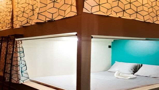 Una cama litera con colchón blanco y cabecera color aguamarina.