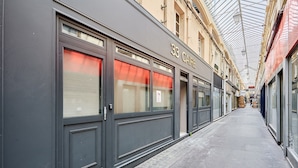 A corridor with storefronts, including a building labeled "33 CAFE". - Charming Studio Center of Paris (Paris)