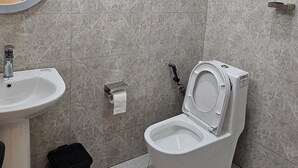 A bathroom with a sink, toilet, and mirror. - Cozy villa (Addis Ababa)