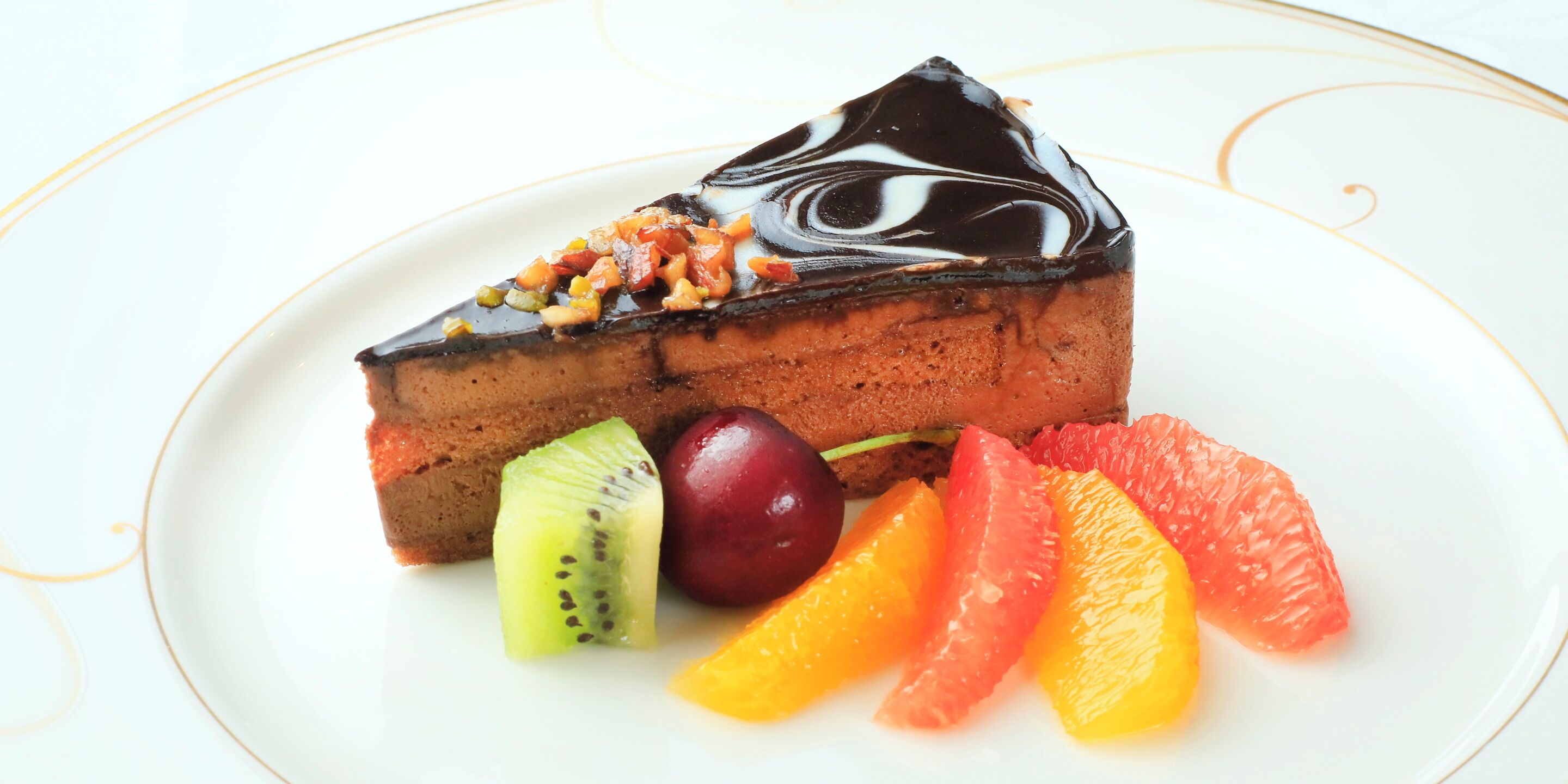 Uma fatia de bolo de chocolate com fruta em um prato.