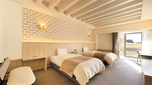 A hotel room with two beds, a desk, a chair, a TV, and a brick wall. - Villa The Club Gotemba West (Gotemba)