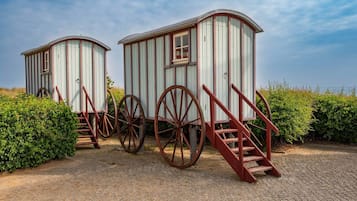 Zwei hölzerne Strukturen auf Rädern mit Treppen, vermutlich historisch oder dekorativ.