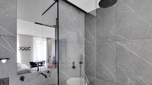 Une salle de bain moderne avec un grand miroir, une baignoire et un espace douche.