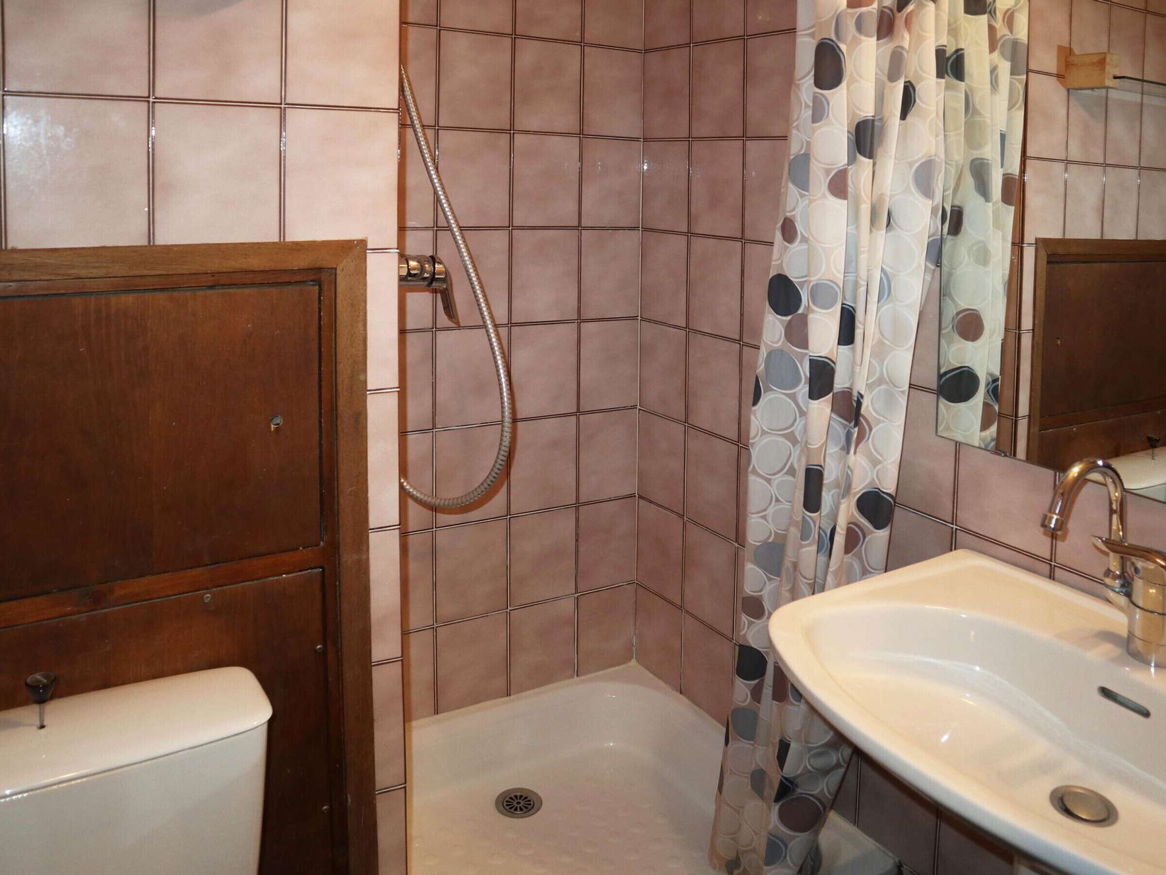 Une salle de bain avec douche, toilettes et lavabo.