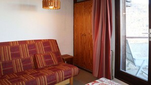 A cozy room with a wooden sofa, a small wooden table, and a large window with curtains. - Studio at Les Orres 1650 for 4 pers, direct slopes access (Les Orres)