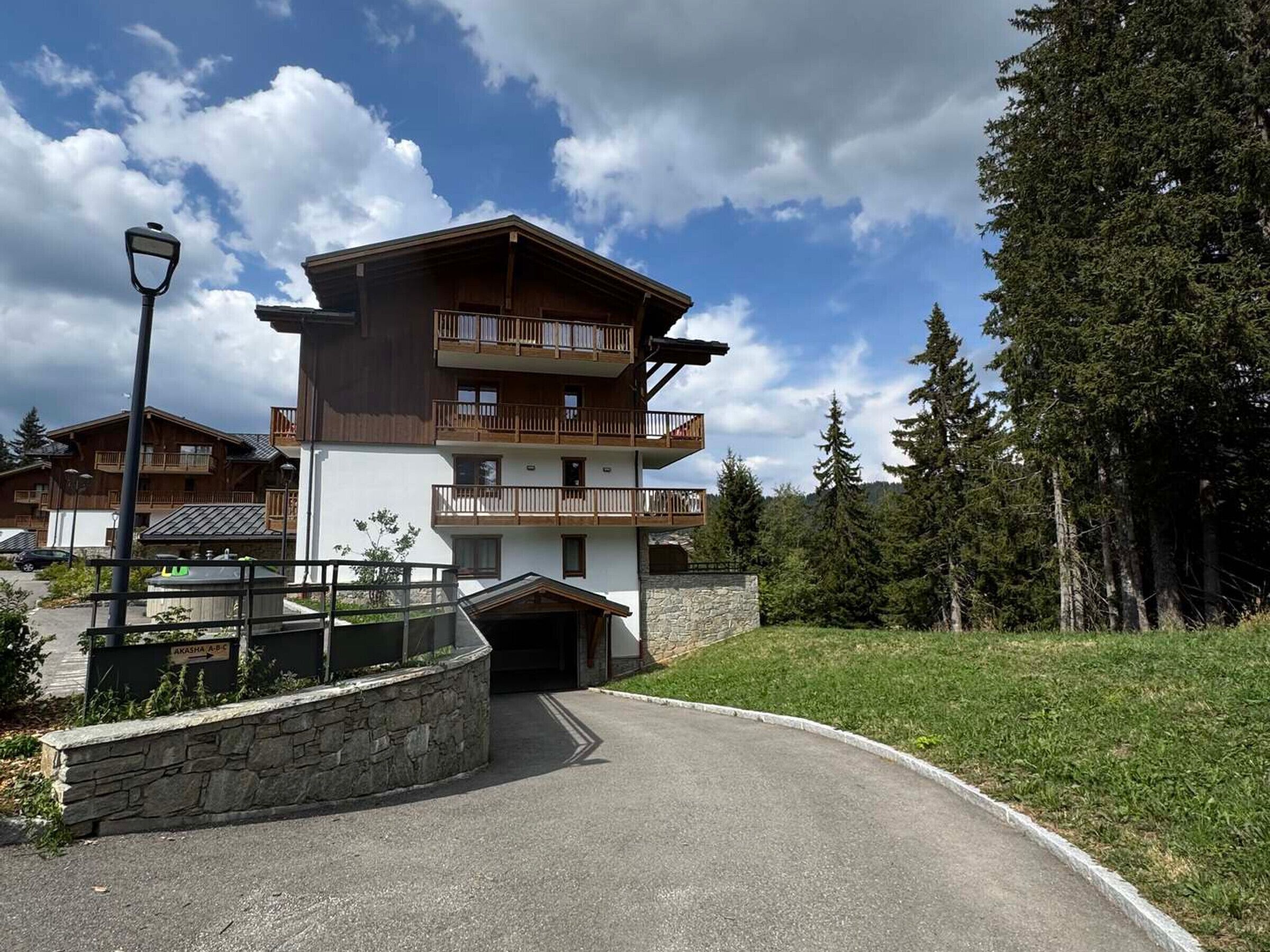 Un immeuble à plusieurs étages doté de balcons, d’un mur en pierre et surplombant un ciel dégagé.