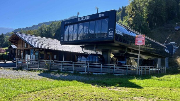 Un albergue de montaña con un gran cartel digital que muestra 'VERCLAND 830m'.