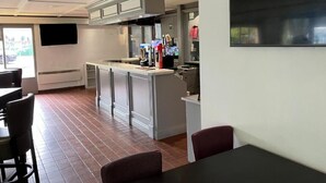 A modern kitchen with white cabinets, a central island, and a dining area with a table and chairs. - The Galleon Hotel, Hull City, Part of the AG Collection (Hull)