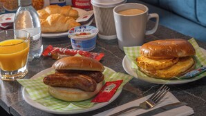 A breakfast table with croissants, sausages, a sandwich, juice, coffee, and cereal boxes. - The Galleon Hotel, Hull City, Part of the AG Collection (Hull)