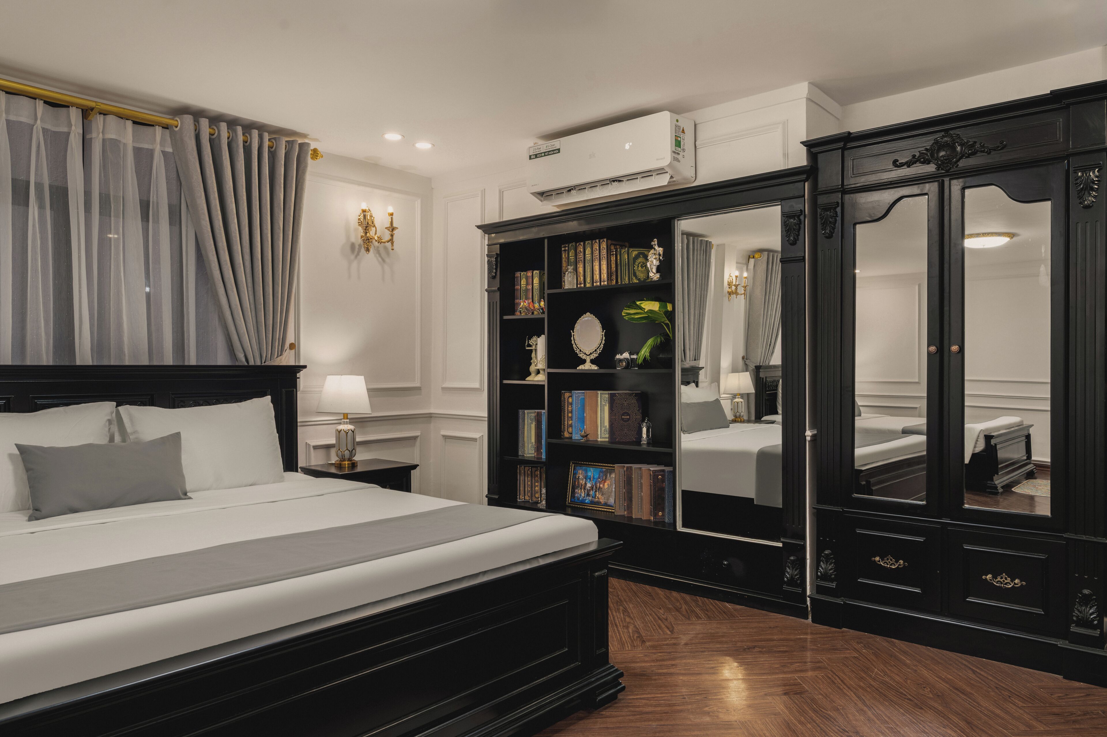 Una camera da letto con un letto grande, una libreria, un armadio e uno specchio.