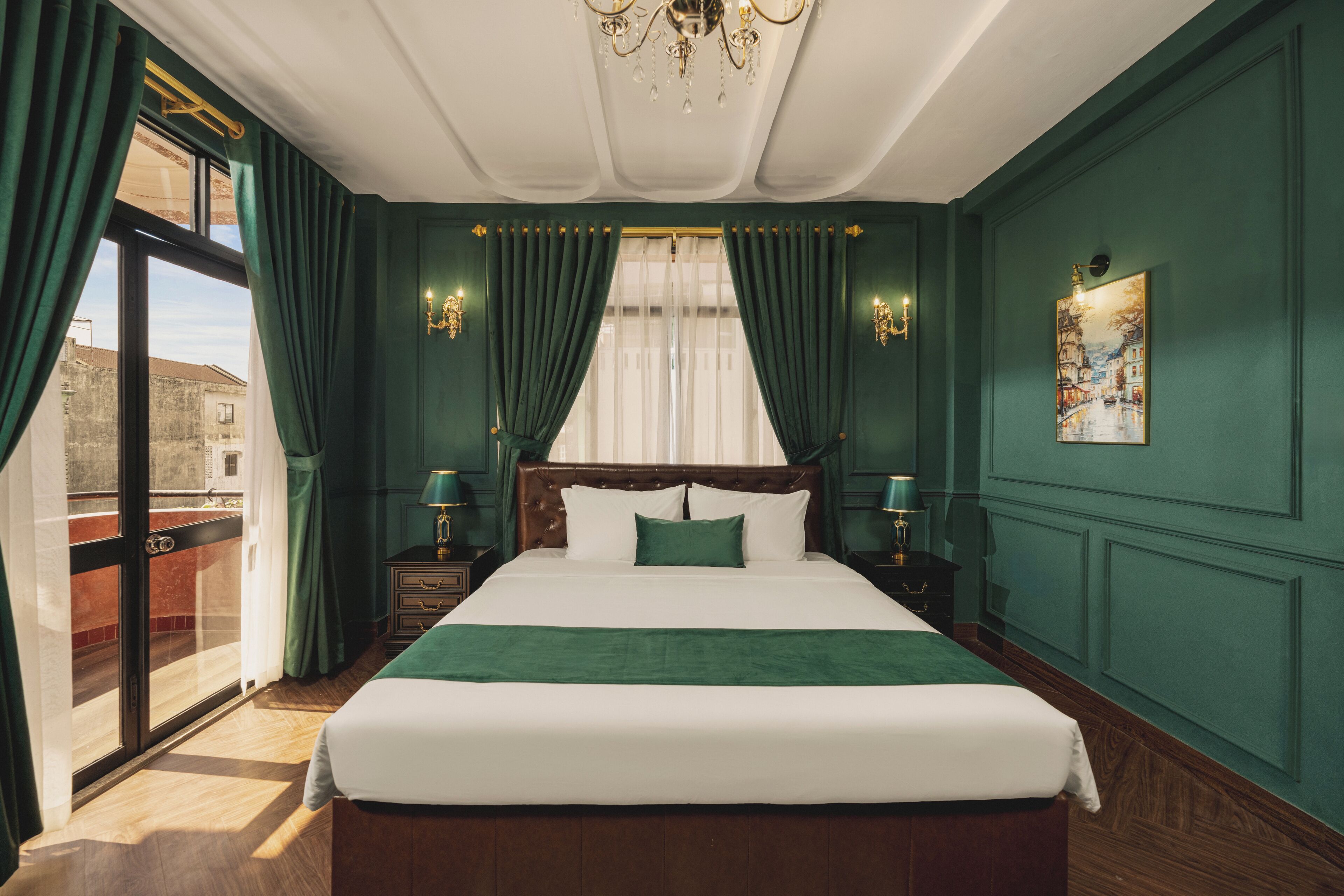 A hotel room with a large bed, green walls, and a view of the city through a sliding door.