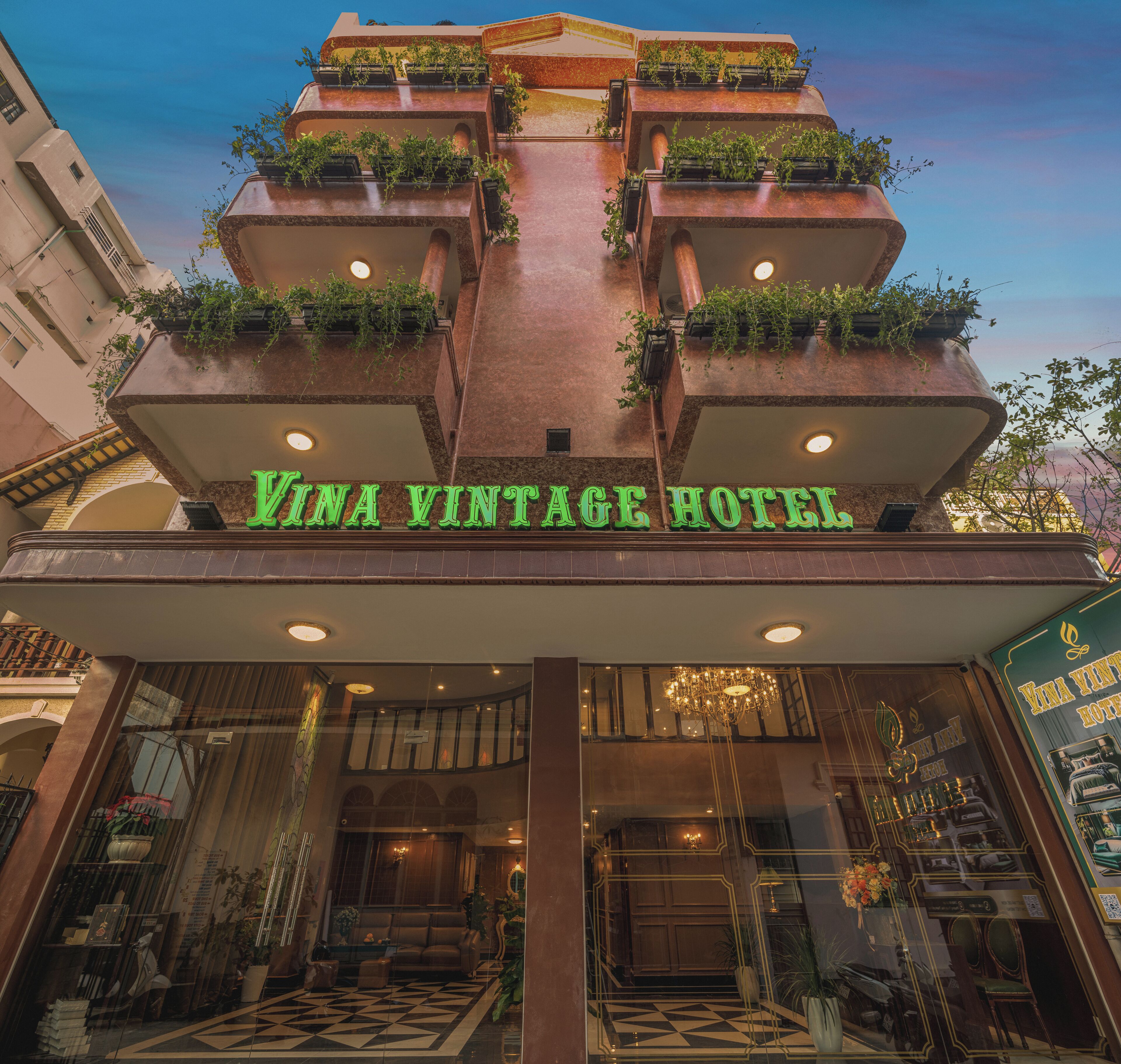 The entrance of Vina Vintage Hotel with a checkered floor and a chandelier.