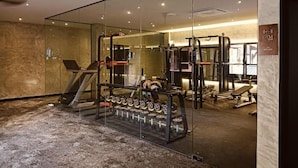 A modern gym with a treadmill, weight machines, and a bench. - BaBa Boutique House Langkawi (Langkawi)