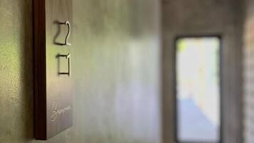 A wall-mounted light switch with a wooden panel and a nameplate.