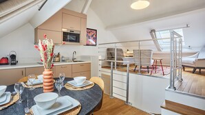 Eine moderne Küche mit Essbereich, einer Treppe und Blick zum Wohnzimmer.