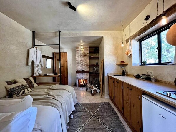 Un dormitorio acogedor con cama, mesita de noche y chimenea.