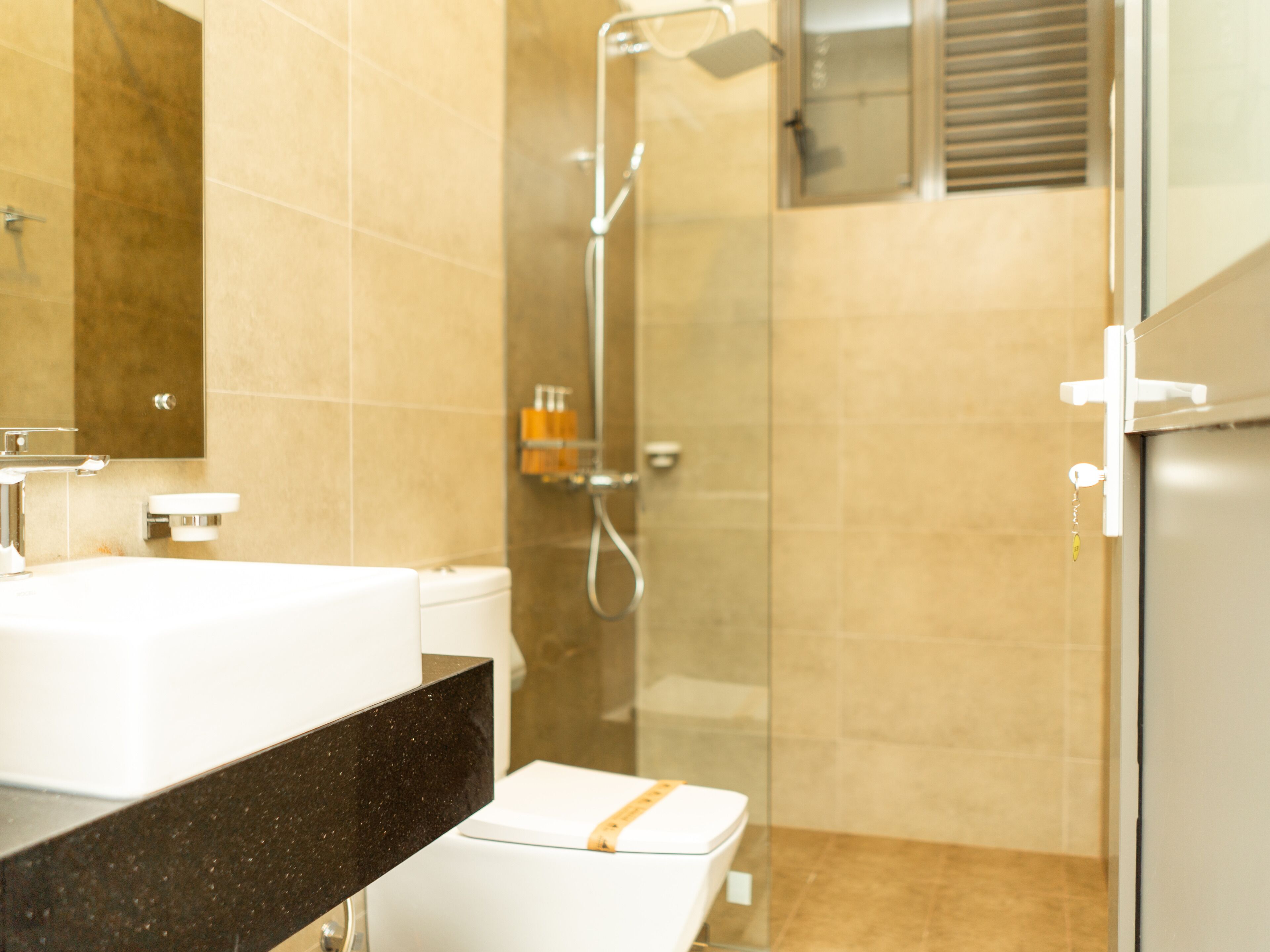 A modern bathroom with a glass shower enclosure, a white sink, and a mirror.