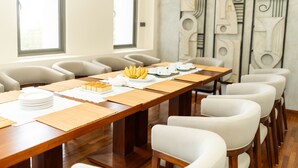 Une salle de conférence avec une longue table, des chaises et un mur décoratif.