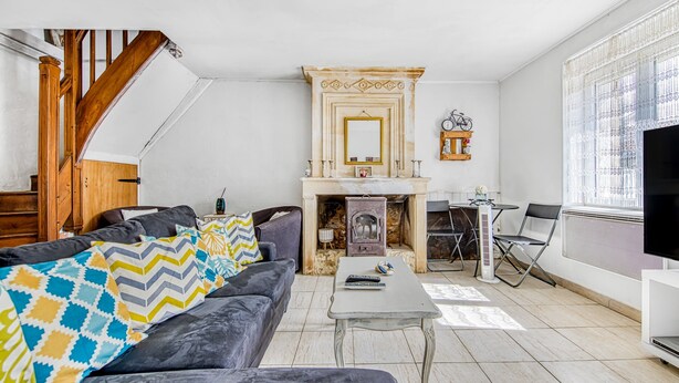 A living room with a fireplace, a sofa, a coffee table, and a TV.
