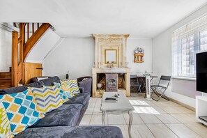 Un salon avec une cheminée, un canapé, une table basse et un téléviseur.