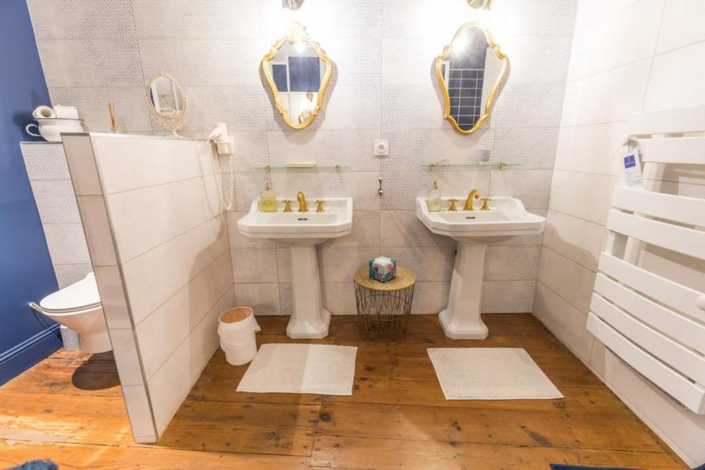 Un baño con dos lavamanos, un inodoro y un espejo.