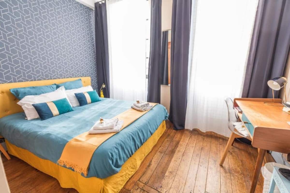 Un dormitorio con una cama, un escritorio y una silla.