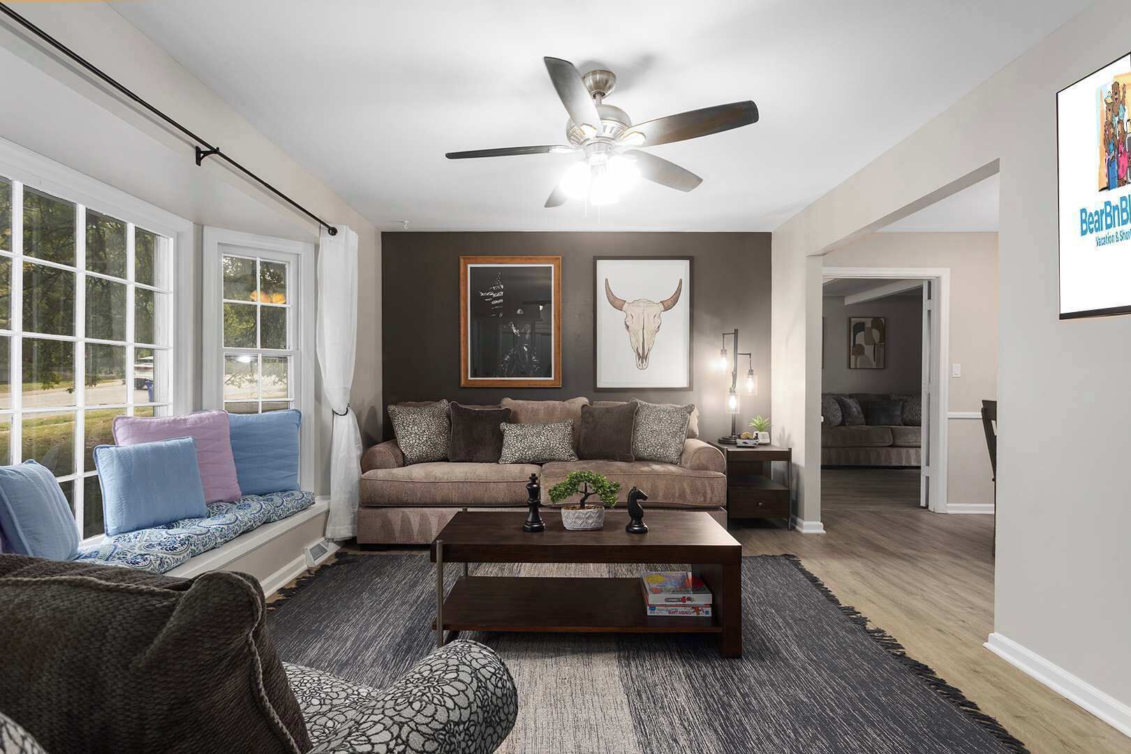 A living room with a sofa, coffee table, and a ceiling fan.