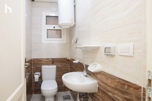 A bathroom with a toilet, sink, and towel rack. - Family stay Apartment in Rehab city (New Cairo)