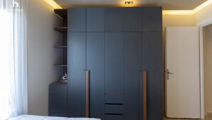 A bedroom with a large wardrobe, a bed, and a door. - Cozy (New Cairo)