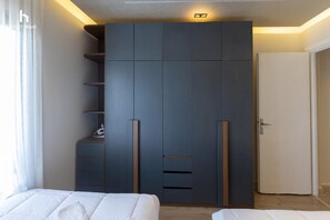 A bedroom with a large wardrobe, a bed, and a door. - Cozy (New Cairo)