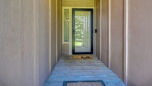 Un couloir étroit menant à une porte sur laquelle est posé un paillasson avec l’inscription « Bonjour ».