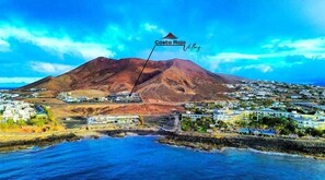 A coastal town with a prominent mountain in the background, named Costa Roja.