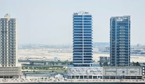 A waterfront hotel with a modern design, featuring a prominent facade with a wave-like pattern and the name "KASCO". - Majestine Stylish Studio with Canal View (Dubai)