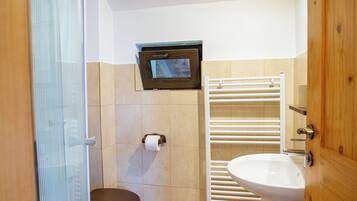 Ein Badezimmer mit Toilette, Waschbecken und Dusche.