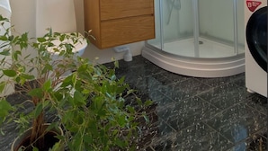 A modern bathroom with a glass shower enclosure, a wooden vanity, and a large mirror. - Exclusive newly apartment with free parking (Västra Götalands län)