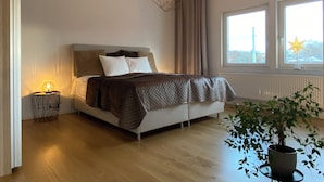 A modern bedroom with a bed, bedside lamp, and a large window with a star decoration. - Exclusive newly apartment with free parking (Västra Götalands län)